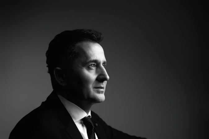 A black-and-white studio side-profile shows a suited man lit with cinematic Rembrandt lighting, an executive portrait.