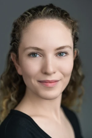 Professional headshot of a smiling woman with soft studio lighting and an authentic, confident expression.